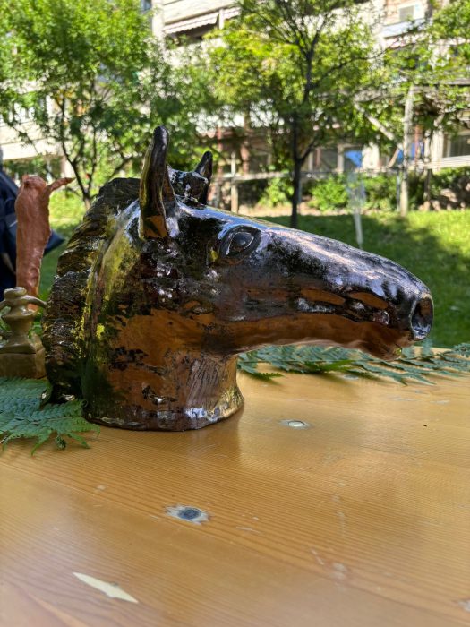 Pferdekopf aus bronzefarbener Keramik. Testa di un cavallo in ceramica color bronzo.