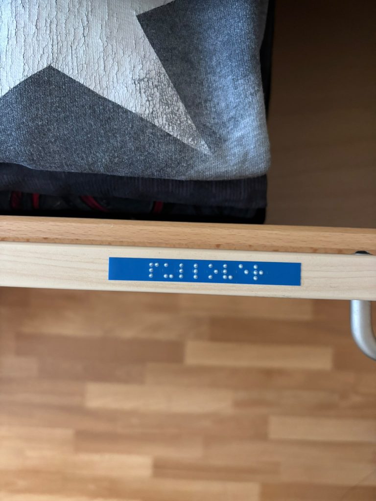 Braille - Schrift am Schrankregal