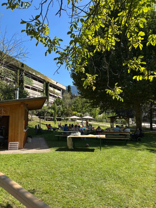 Garten mit Personen an Tischen im Freien